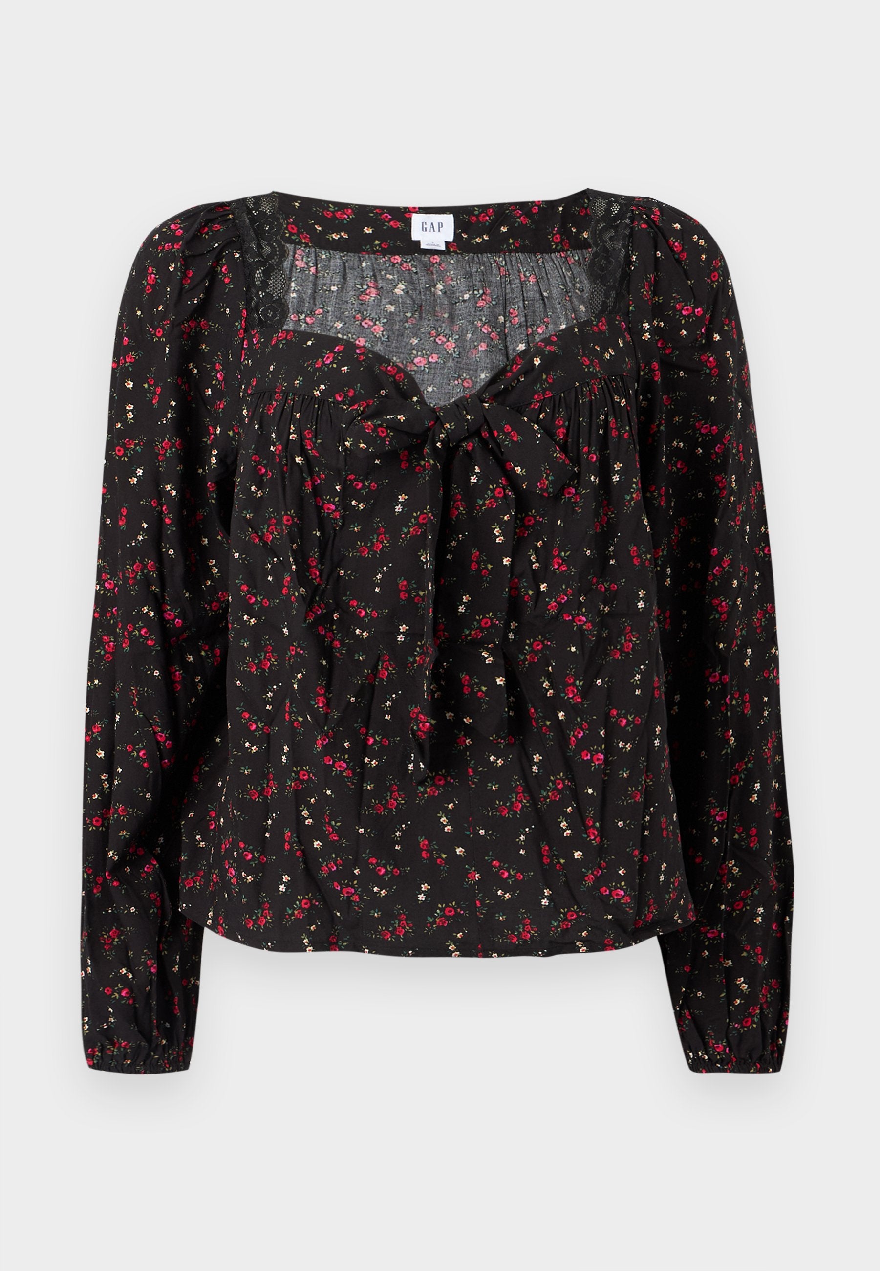 Schwarze Bluse mit Blumenmuster und langen Ärmeln, vorne mit Bindeband, gerafften Details und kleinen roten und weißen Blumenmustern auf der gesamten Fläche.