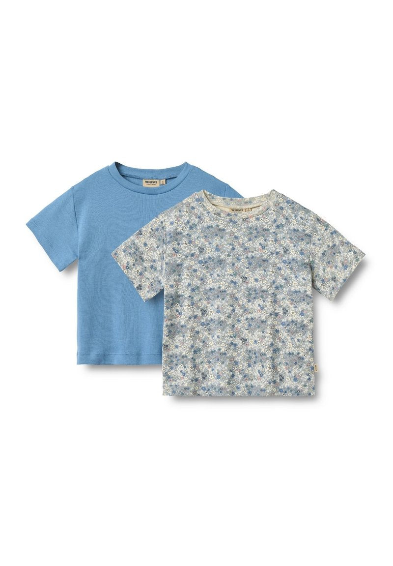 Zwei T-Shirts: eines in einfarbig hellblau, das andere mit floralem Muster in hellblau und weiß. Beide haben kurze Ärmel und runde Ausschnitte.