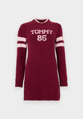 Bordeauxrotes Strickkleid mit langen Ärmeln, versehen mit weißem "TOMMY 85" Schriftzug und hellrosa Streifen an den Ärmeln. Gerippte Bündchen und Halsausschnitt.
