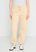 Beige Sweatpants aus einem Baumwollmix mit elastischem Bund, verstellbarem Kordelzug, schmal zulaufenden Beinen und Seitentaschen. Kombiniert mit gemusterten Turnschuhen.