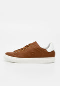 Brauner Leder-Low-Top-Sneaker mit weißem Fersenakzent, weißer Gummisohle, braunen Schnürsenkeln und goldenen Ösen, seitlich auf weißem Hintergrund gesehen.