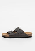 Dunkelbraune Ledersandalen mit zwei verstellbaren Riemen, einem Korkfußbett und einer strukturierten schwarzen Gummisohle. Mit silbernen Schnallen zur Schließung.