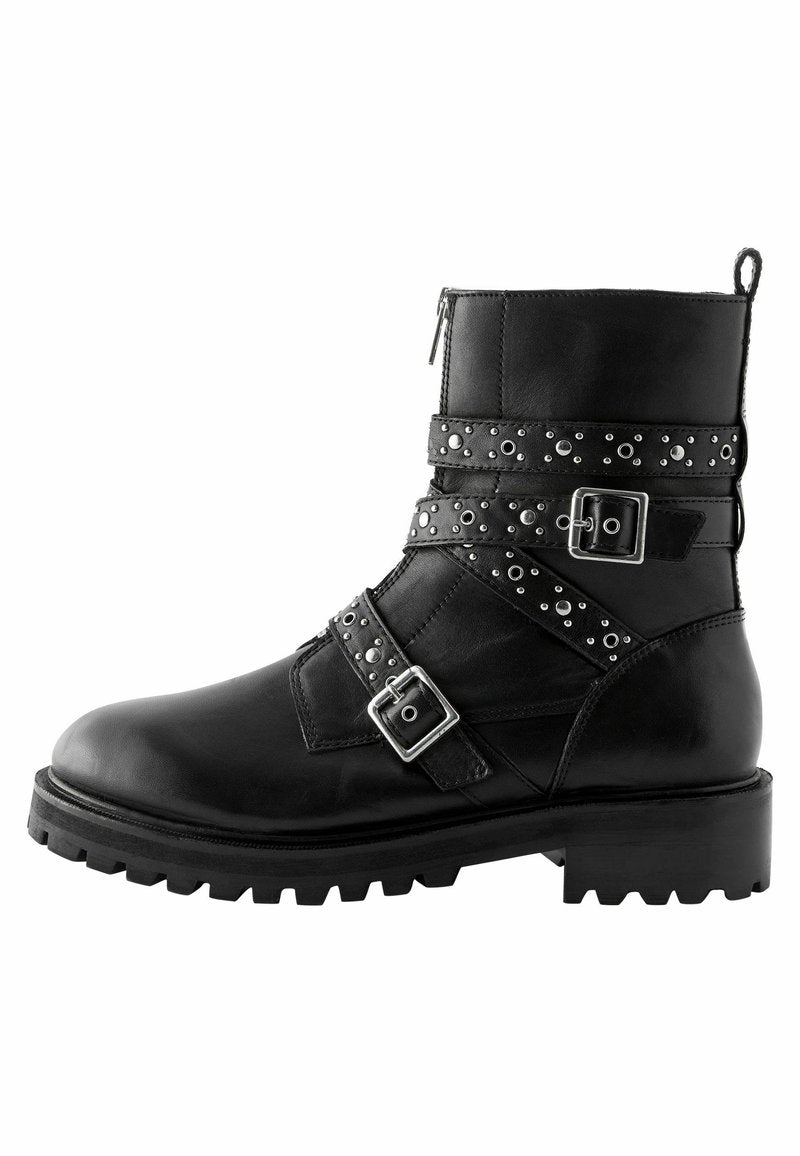 Schwarze Leder-Stiefeletten mit Schnallen und genagelten Riemen, runde Zehenpartie und klobige Profilsohle. Mit seitlichem Reißverschluss für einfachen Zugang.
