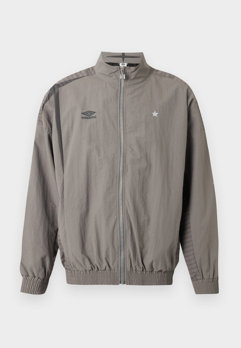 Hellgraue Sportjacke mit Reißverschluss, Umbro-Logo auf der linken Brust und Stern-Emblem auf der rechten Brust, elastischen Bündchen und Saum sowie gestreiftem Schulterdetail.