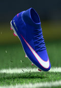 Der Nike Mercurial Fußballschuh in Blau mit weißen und pinkfarbenen Akzenten zeichnet sich durch ein schlankes Design, ein strukturiertes Obermaterial und geformte pinkfarbene Stollen für optimalen Halt aus.