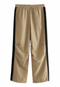 Beige Cargo-Hosen aus strukturiertem Stoff, mit schwarzen Seitenstreifen, einem elastischen Bund und Seitentaschen. Lässiger Schnitt.
