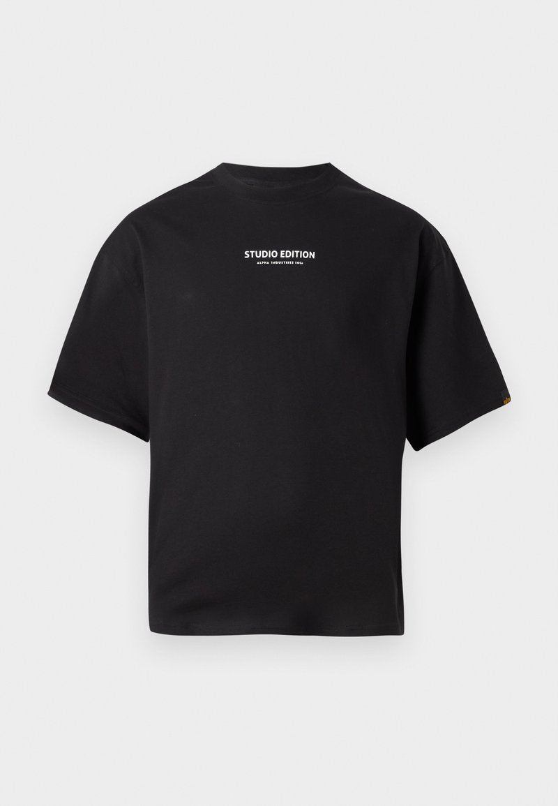 Schwarzes Kurzarm-T-Shirt mit weißem, zentral auf der Brust platziertem Text "STUDIO EDITION ALPHA INDUSTRIES INC." auf einem schlichten Hintergrund.