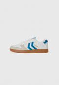 Weiße Sneaker mit hellgrauen Wildlederakzenten und blauem Chevron-Design. Verfügt über eine strukturierte Gummisohle und eine Schnürung. Goldene Markierung.