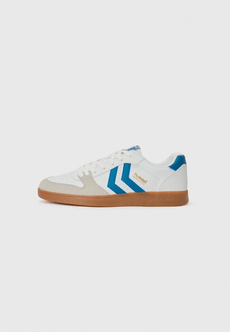 Weiße Sneaker mit hellgrauen Wildlederakzenten und blauem Chevron-Design. Verfügt über eine strukturierte Gummisohle und eine Schnürung. Goldene Markierung.