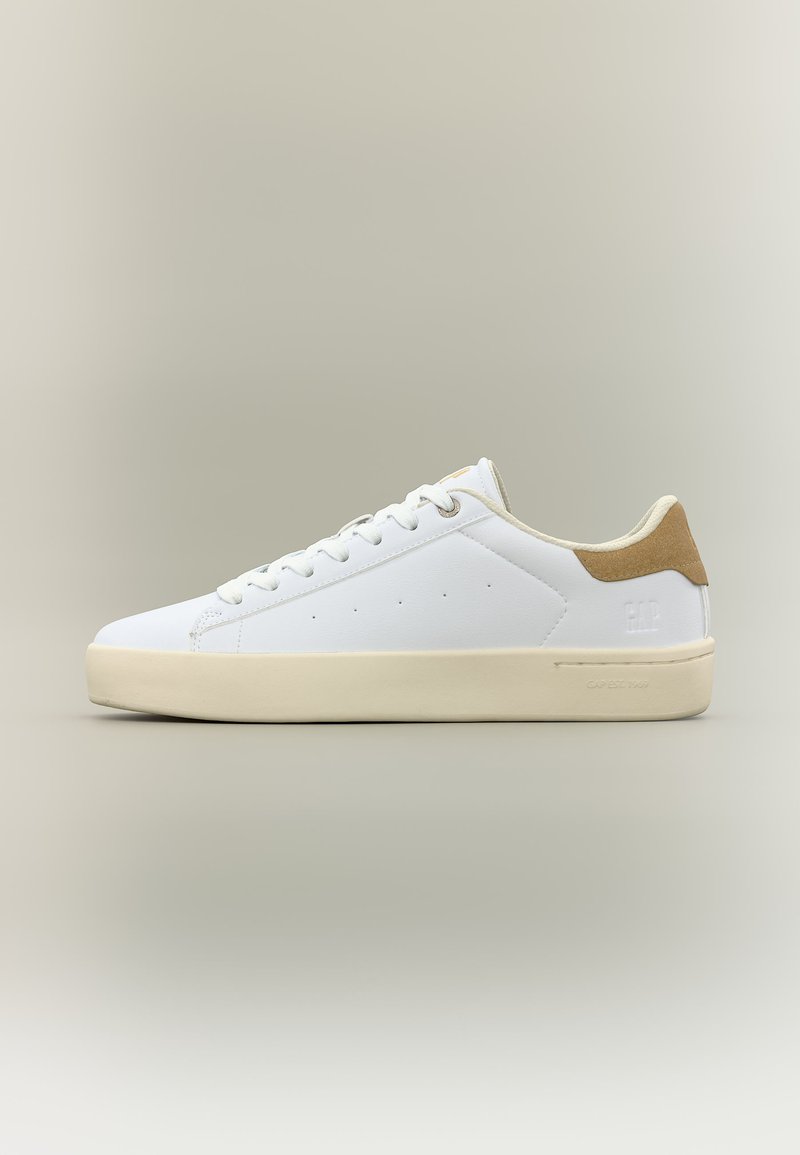 Weißer Sneaker mit niedrigem Schaft, beigefarbener Sohle und hellbraunem Veloursleder-Fersenpatch, Schnürdesign und minimalen Perforationsdetails an der Seite.