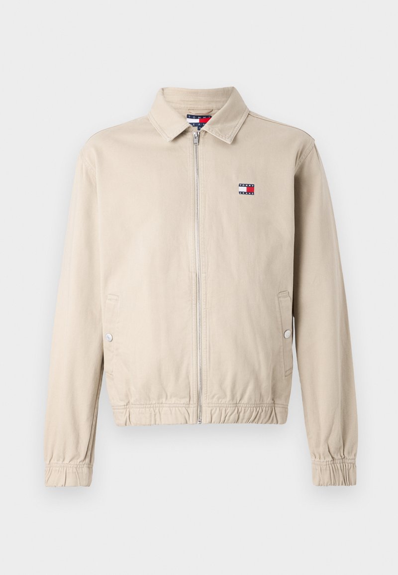 Khakifarbene Jacke mit Reißverschluss, Kragen, elastischen Bündchen und tailliertem Schnitt. Mit kleinem Logo auf der linken Brust. Glatte Stoffstruktur.