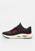 Seitenansicht eines schwarzen und dunkelroten Sneakers mit beiger Sohle und atmungsaktivem Mesh-Obermaterial.