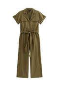 Olivgrüner Jumpsuit aus leichtem Stoff. Mit kurzen Ärmeln, tailliertem Gürtel, zwei Brusttaschen und einem Kragen. Weit geschnittene Beine.