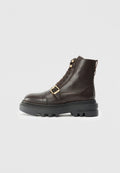 Braune Leder-Stiefelette mit einer massiven schwarzen Sohle, Schnürdesign, goldenen Hardware-Akzenten und einem Riemen mit Schnallen-Detail über dem Mittelfuß.