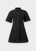 Schwarzes kurzärmeliges Hemdkleid mit weißen Kontrastnähten, durchgehender Knopfleiste, strukturierten Taillennähten und Kragen.