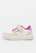 Weißer und beiger Kindersneaker mit pinken Schnürsenkeln, einem beigen Klettverschluss und lila Akzenten auf einer weißen Sohle.