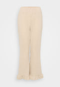 Cremfarbene, gerippte Strickhosen mit einem elastischen Taillenbund und einem ausgestellten Saum, der am unteren Rand Rüschendetails aufweist. Glatte Textur.