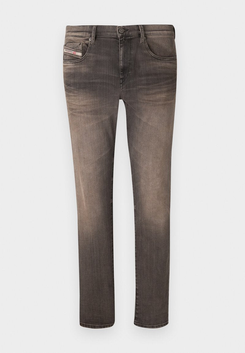 Schlanke Jeans in einem verblassten schwarzen Farbton, mit fünf Taschen, Gürtelschlaufen und einem Reißverschluss. Das Material zeigt eine leichte Textur mit subtilen Abnutzungserscheinungen.