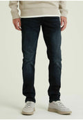 Dunkelblaue Jeans im Slim Fit mit klassischem Fünf-Taschen-Design und subtilen Ausbleichungen, kombiniert mit hellen Sneakers.