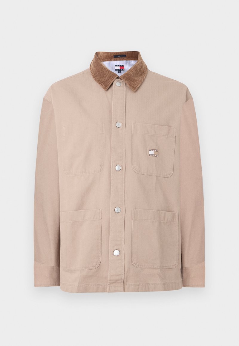 Beige Knopfjacke mit braunem Cordkragen, Brusttasche mit Tommy Jeans-Logo und zwei unteren Fronttaschen.