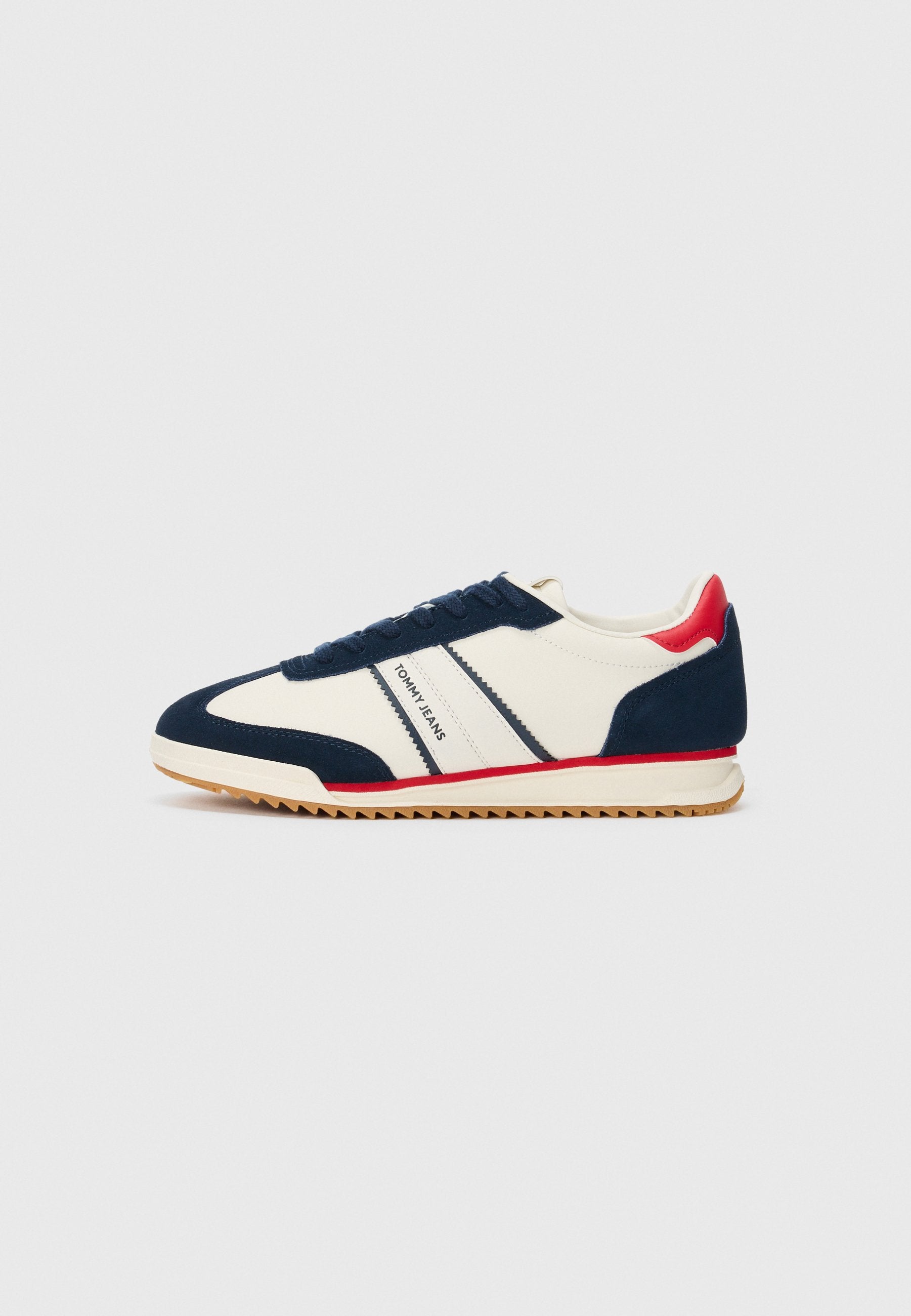 Weißer Sneaker mit marineblauen und roten Akzenten, strukturiertem Sohle, Schnürdesign und "Tommy Jeans"-Branding an der Seite.