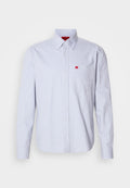 Hellblaues Hemd mit Knöpfen aus Stoff mit glatter Textur. Verfügt über ein kleines rotes Logo auf der Brusttasche und einen Button-Down-Kragen.