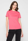 Rosa Baumwoll-T-Shirt mit Rundhalsausschnitt und kurzen Ärmeln. Kleines Logodetail auf der Brust. Kombiniert mit schwarzen Jeans.