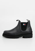 Schwarzer Leder-Stiefel mit elastischen Seitenpanelen, genoppter Sohle und einem Markenpatch an der Seite, im traditionellen Chelsea-Design.