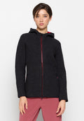 Schwarze Fleecejacke mit Struktur, Kapuze, Frontreißverschluss und zwei Seitentaschen. Mit roten Akzenten entlang des Reißverschlusses und der inneren Kapuze.