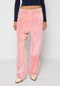 Rosa Velour-Hosen mit weitem Bein und elastischem Bund, die eine weiche Textur und minimale Marke aufweisen, kombiniert mit einem figurbetonten marineblauen Oberteil.