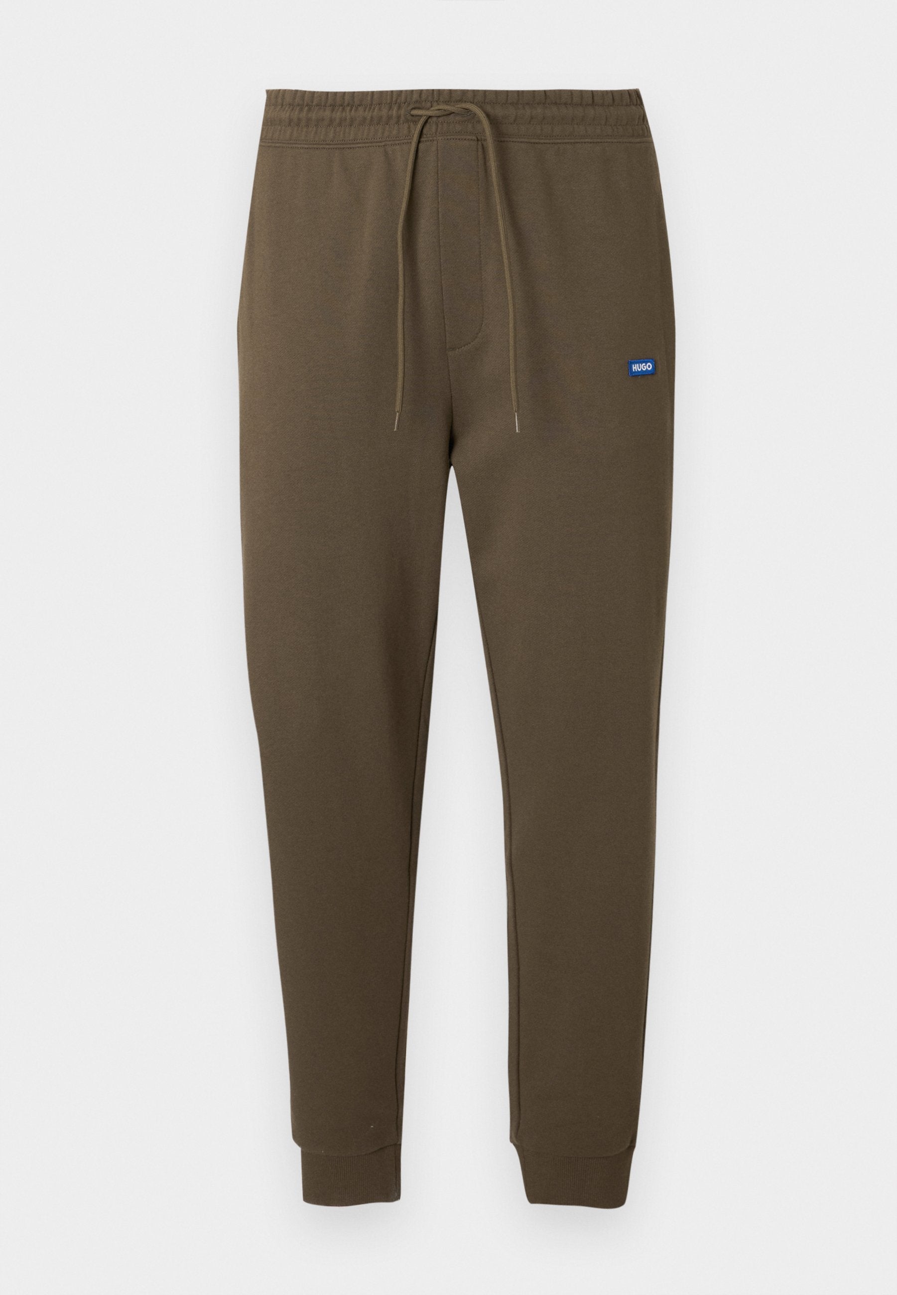 Dunkel olivgrüne Sweatpants mit elastischem Bund, Kordelzug, seitlichen Taschen und gerippten Bündchen. Kleines blaues Logo-Patch auf der linken Seite.