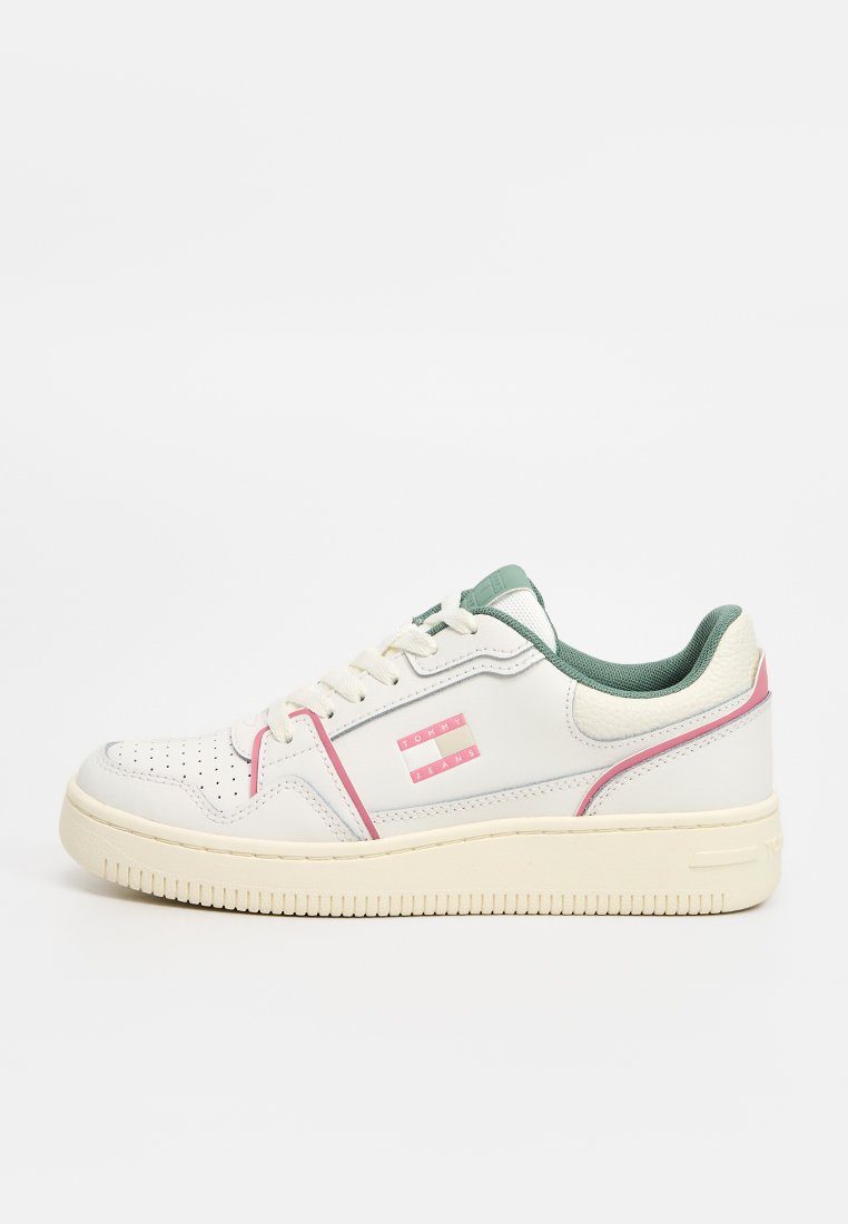 Weißer Sneaker mit niedrigem Schaft, grüner Innenausstattung, pinken Akzenten, perforierter Zehenpartie und "Tommy Jeans"-Logo an der Seite.