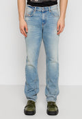Helles blaues Denim-Jeans mit lockerer Passform, ausgewaschenem Finish, fünf Taschen und geradem Bein, gezeigt mit grünen Schuhen.