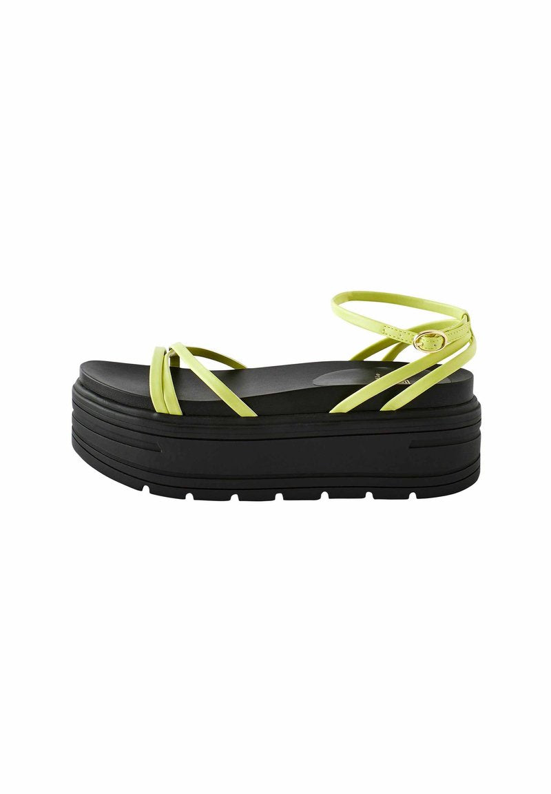 Schwarze Plateausandalen mit strukturiertem Fußbett, die leuchtend gelbe Riemen und einen verstellbaren Knöchelriemen haben.
