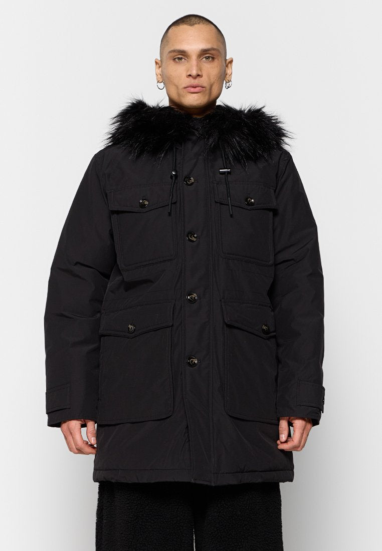 Schwarze Parkajacke mit einer Kapuze aus Kunstfell, ausgestattet mit mehreren Fronttaschen, Druckknöpfen und einem schlanken Design. Hergestellt aus einem strukturierten Stoff.