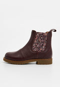 Burgunderrote Leder-Stiefelette mit seitlichem elastischen Blumenmuster, brauner Gummisohle, abgerundeter Zehenpartie und Zugschlaufe auf der Rückseite.