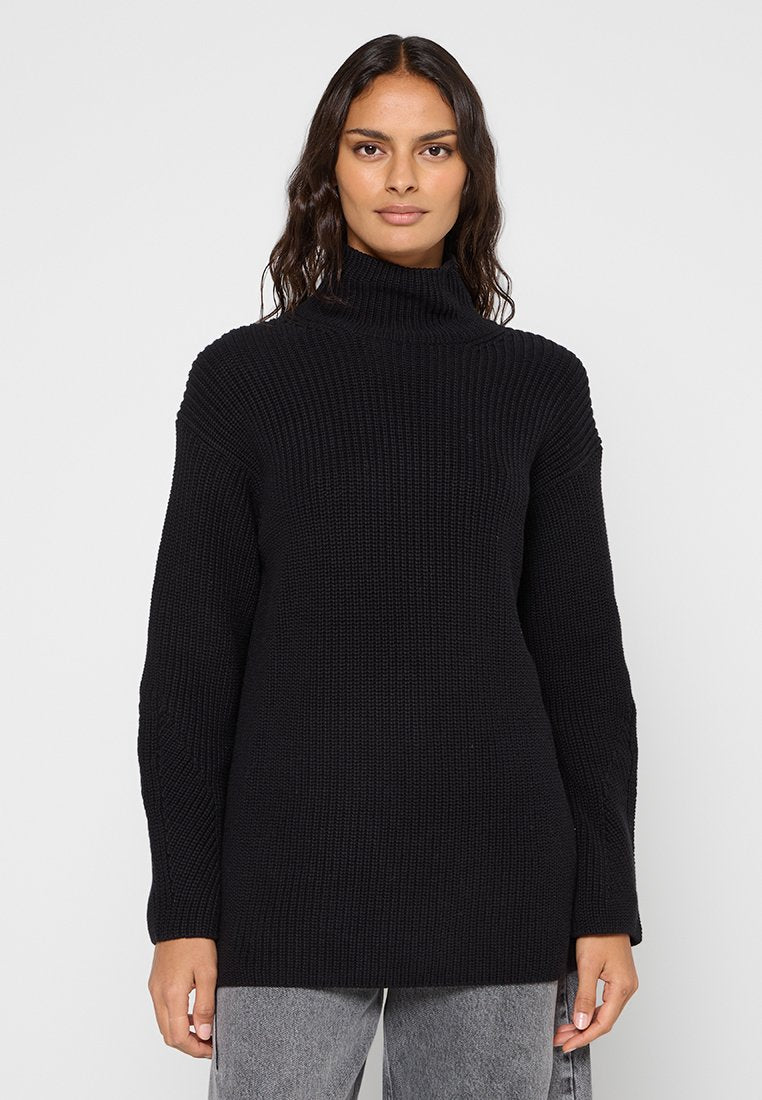 Schwarzer Rollkragenpullover aus geripptem Strickstoff, mit langen Ärmeln und einem lockeren Schnitt, vor einem schlichten weißen Hintergrund präsentiert.