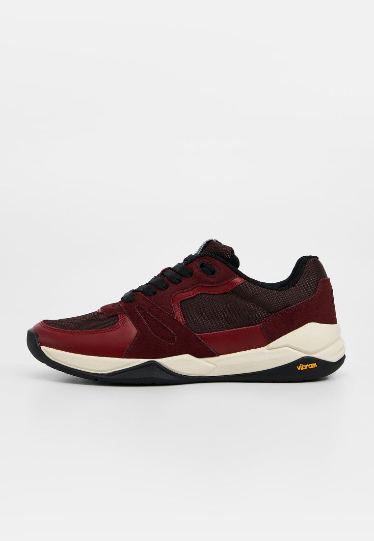 Maroonfarbener und schwarzer Sportschuh mit einer Kombination aus Leder- und Mesh-Obermaterial, abgerundeter Spitze, dicker Sohle und Vibram-Logo an der Ferse.