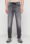 Graue Jogginghosen aus Denim, mit einem Kordelzugbund und Fronttaschen. Der Stoff hat eine ausgewaschene und abgenutzte Textur.