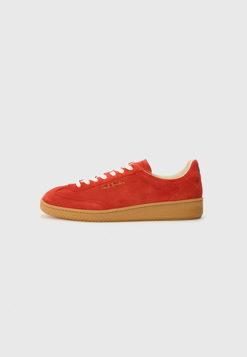 Rote Wildleder-Sneaker mit weißen Schnürsenkeln, hellbrauner Gummisohle und goldener Branding auf der Seite. Abgerundete Spitze und flaches Design.