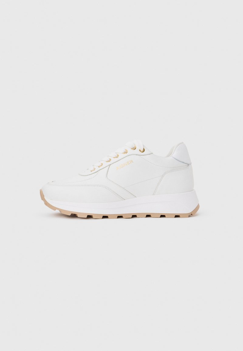 Weißer Low-Top-Sneaker mit beiger Sohle, goldenen Ösen und seitlichem Branding, dargestellt auf neutralem grauem Hintergrund.