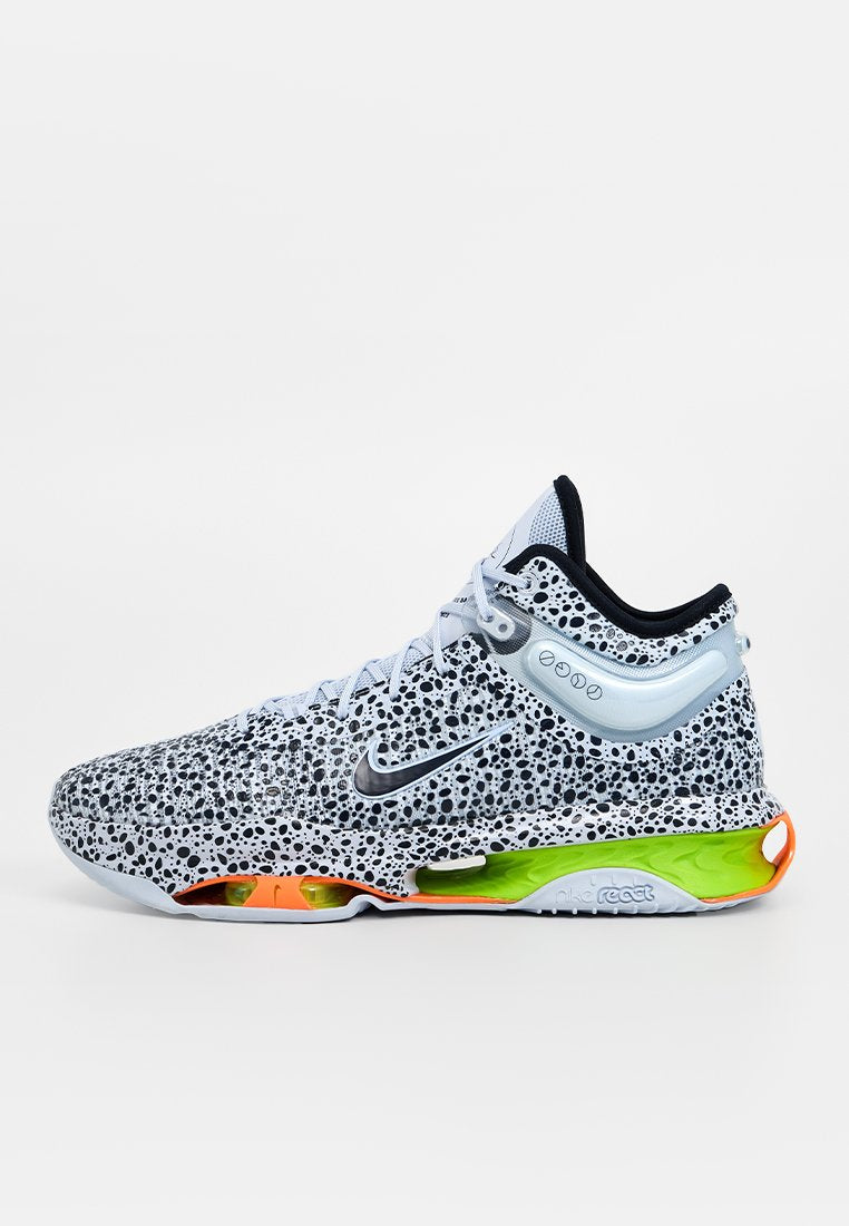 Nike-Sneaker mit einem grauen und schwarzen gesprenkelten Obermaterial, einem blauen Akzent, einer neongrünen und orangen Sohle sowie einem strukturierten Design.