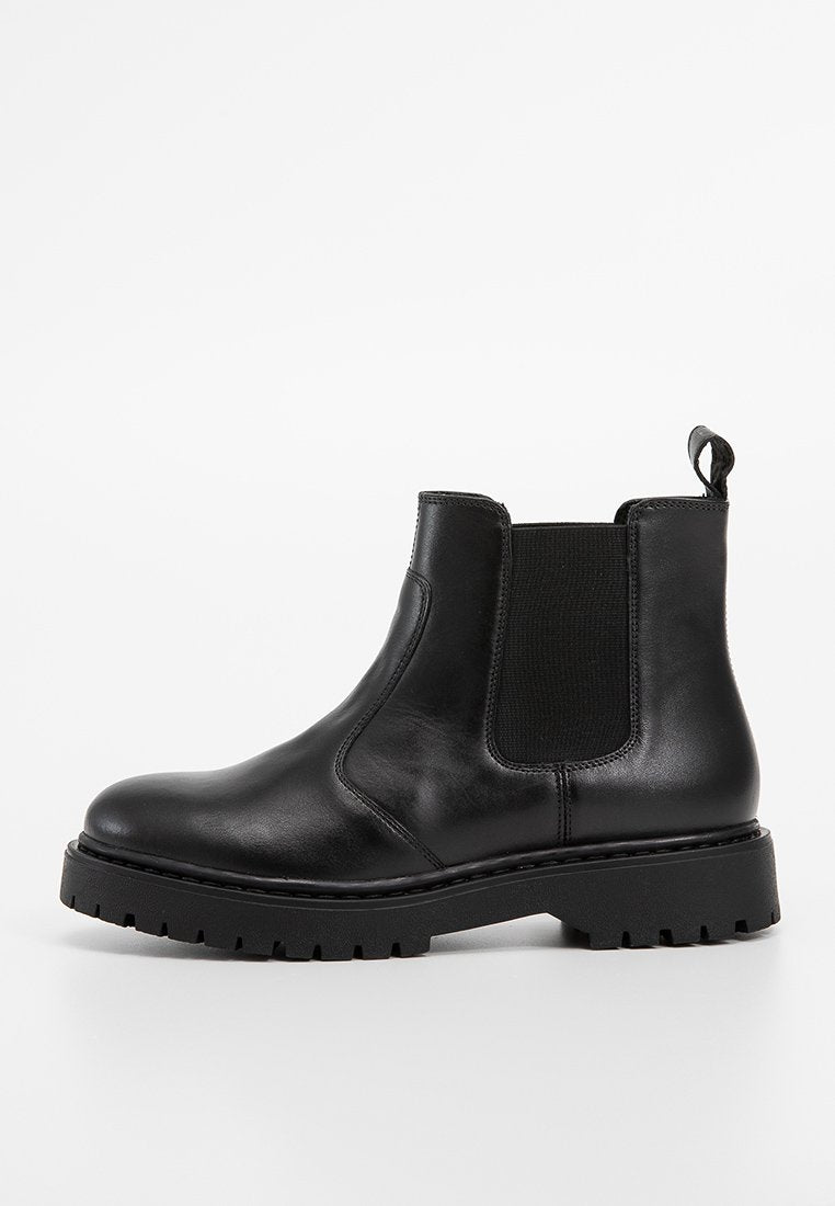 Schwarze Leder-Chelsea-Stiefel mit elastischen Seiteneinsätzen, runder Zehenpartie, dicker Gummisohle und einer Zuglasche auf der Rückseite für ein einfaches An- und Ausziehen.