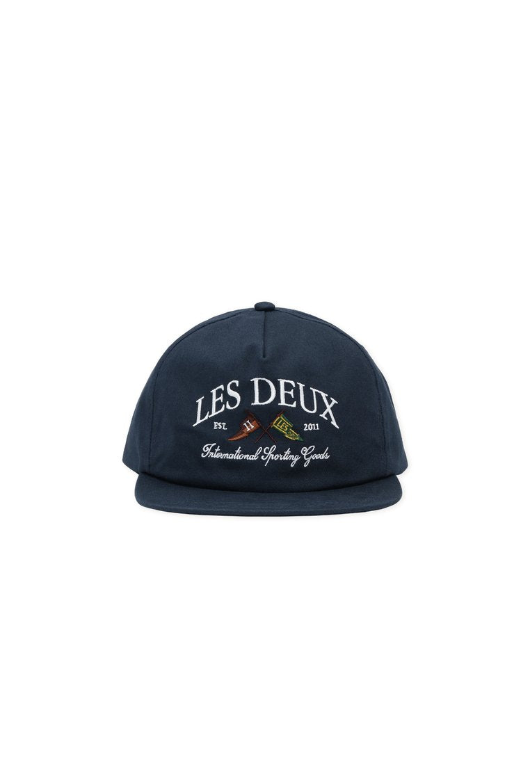 Marineblaue Kappe aus Baumwolle mit flachem Schirm. Verziert mit gesticktem Text und zwei gekreuzten Symbolen, beschriftet mit "LES DEUX" und "International Sporting Goods."