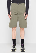 Mann trägt olivgrüne knielange Shorts, schwarzes Langarmshirt, schwarze Socken und mehrfarbige Laufschuhe, steht in Frontalansicht.