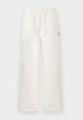 Off-white gerade geschnittene Hose mit elastischem Bund und kleinem rotem Fleck auf der rechten Seite, vor einem schlichten hellen Hintergrund präsentiert.