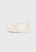 Kinderschuh mit Akzenten in Pastellrosa, Lavendel und Gelb, ausgestattet mit zwei weißen Klettverschlüssen und weißer Sohle.