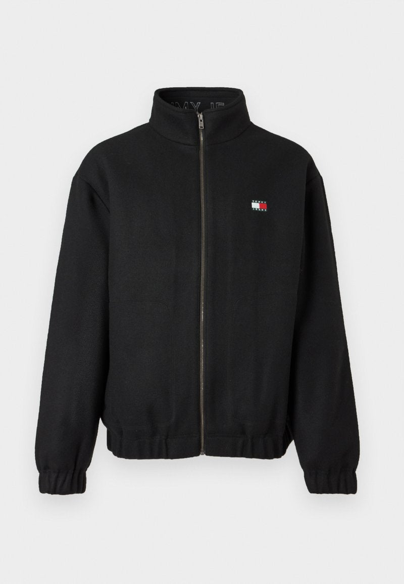 Schwarze Zip-Jacke aus weichem Stoff mit hohem Kragen. Verfügt über ein kleines Logo in Rot, Weiß und Blau. Elastische Bündchen und Saum.