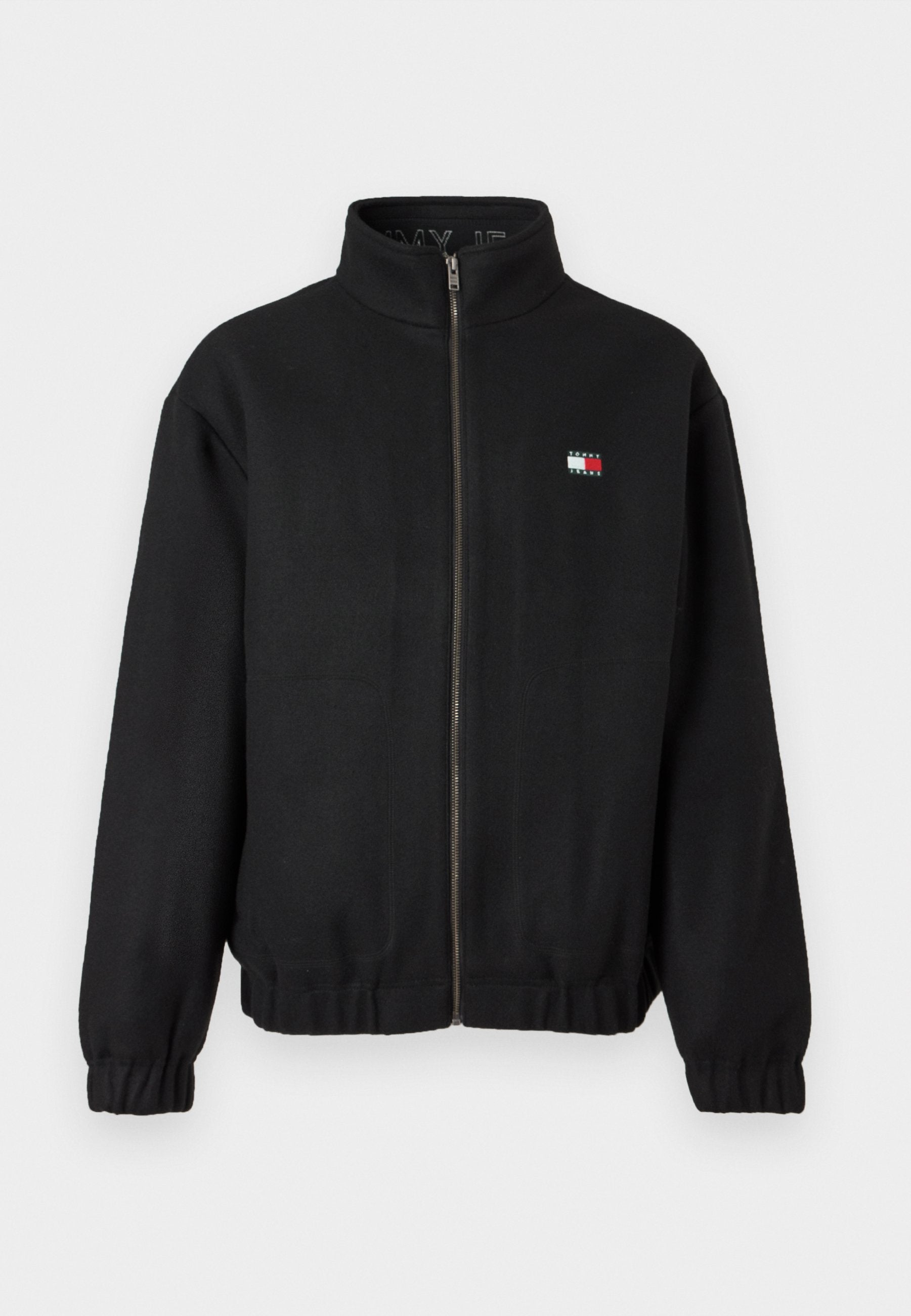 Schwarze Zip-Jacke aus weichem Stoff mit hohem Kragen. Verfügt über ein kleines Logo in Rot, Weiß und Blau. Elastische Bündchen und Saum.
