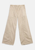 Beige Hosen mit weitem Bein, elastischem Bund, Seitentaschen und sichtbaren Nahtdetails an Vorderseite und Beinen.